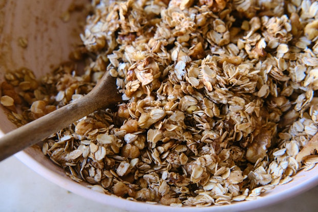 oats and other ingredients combined in a bowl to make granola