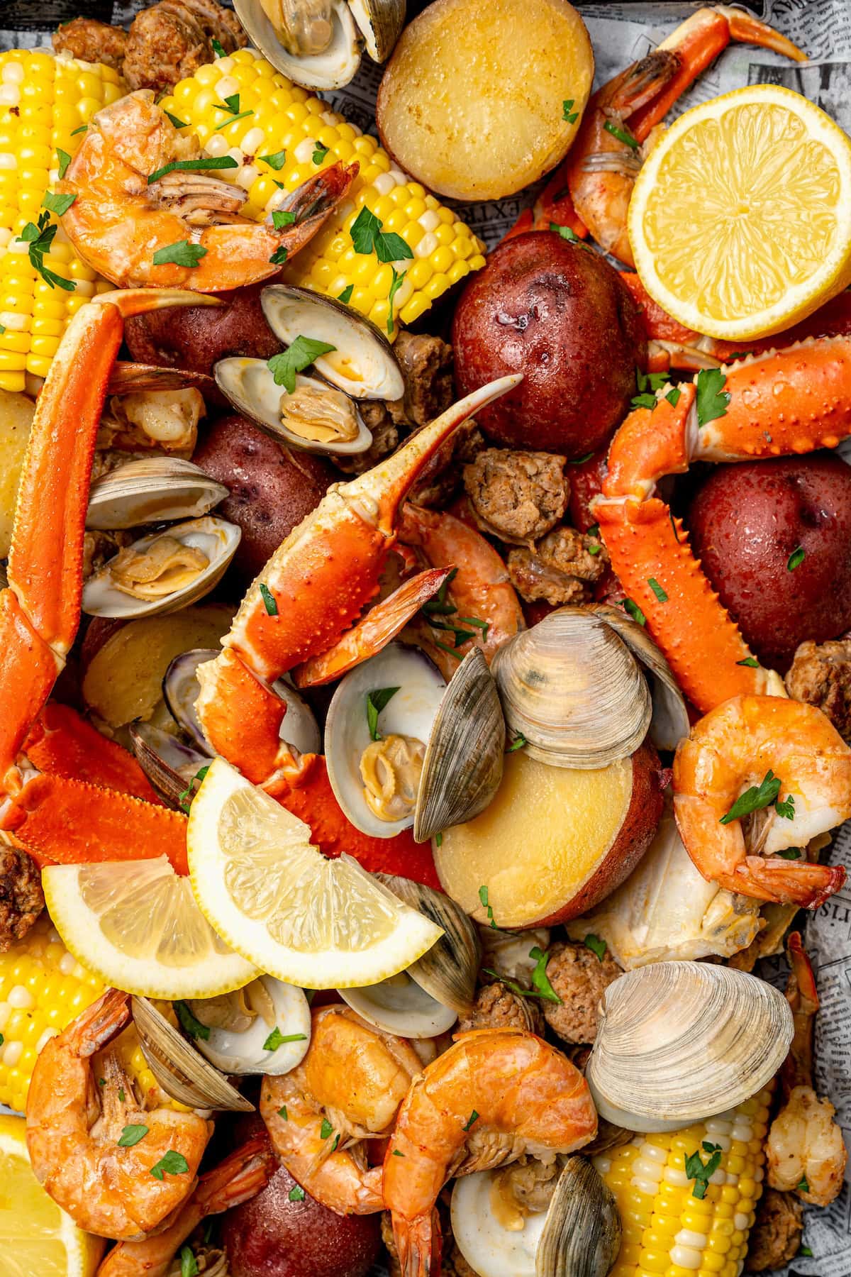With spicy chorizo, potatoes, corn, crab, clams and shrimp, this seafood boil recipe is a complete meal in one pot. So easy to make too! Overhead view of seafood boil with lemon slices