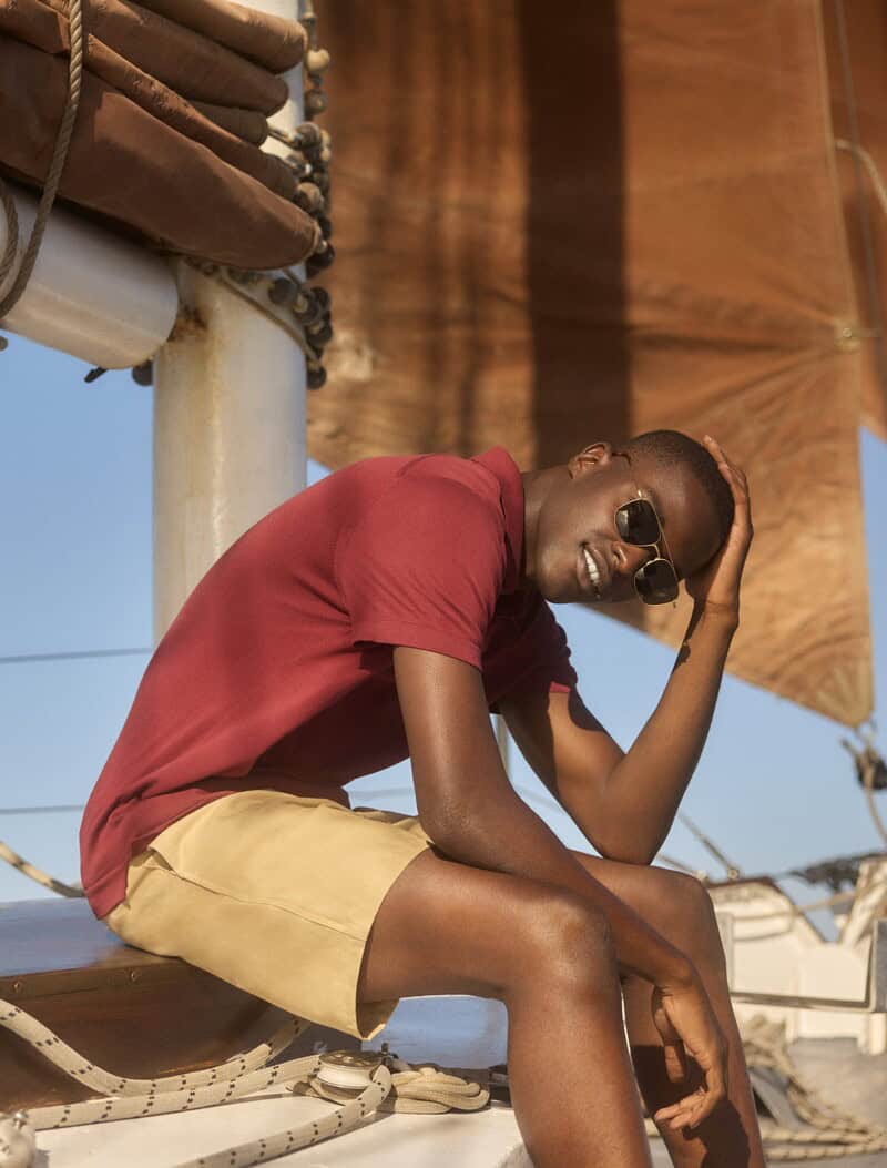 Man on a boat wearing Red Polo Shirt and Khaki Shorts
