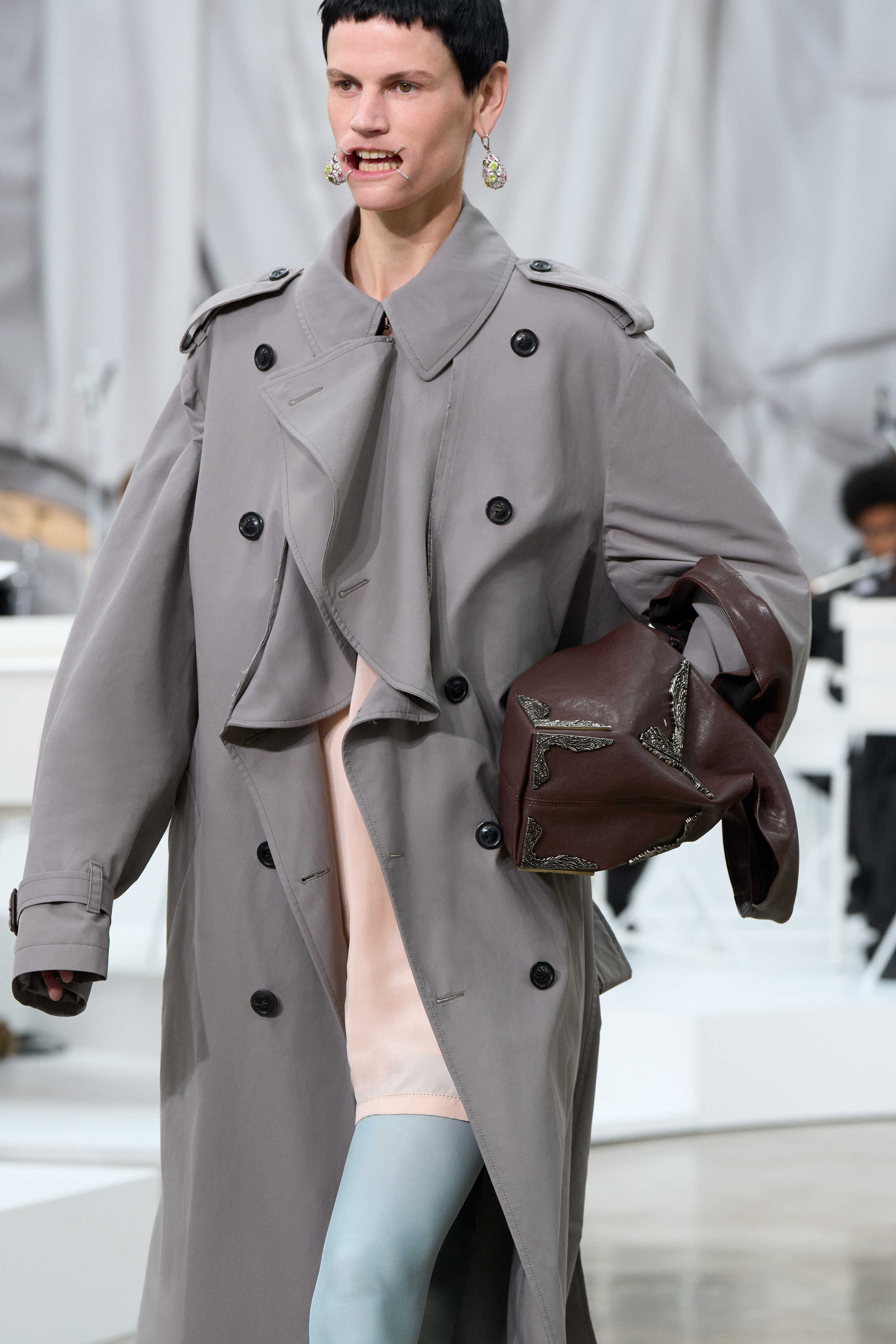 A close-up image of a model at the S/S 26 Maison Margiela show carrying a slouchy, oversized bag.