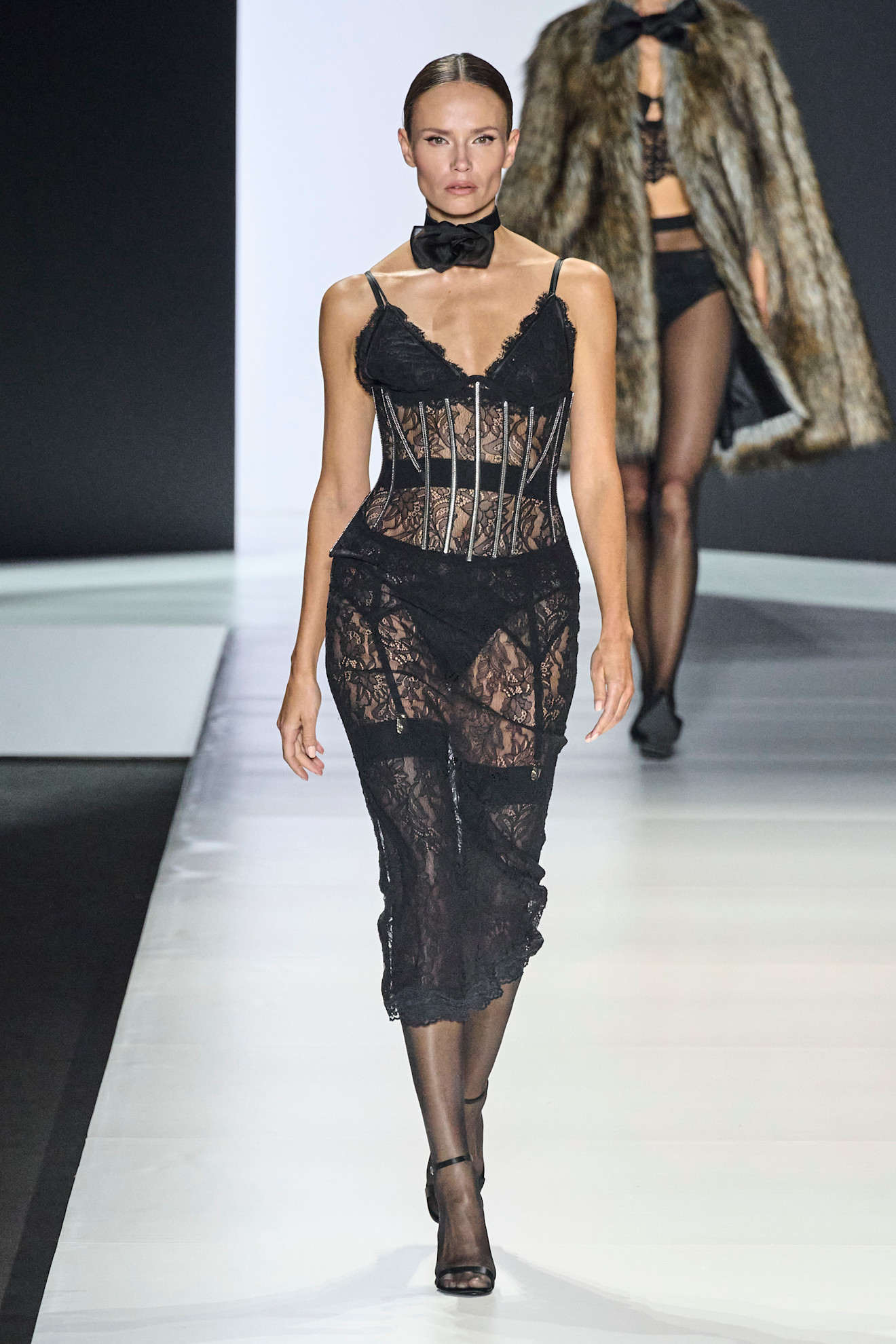 A model walking in the S/S 25 Dolce &amp; Gabbana show wearing a black lace sheer dress.