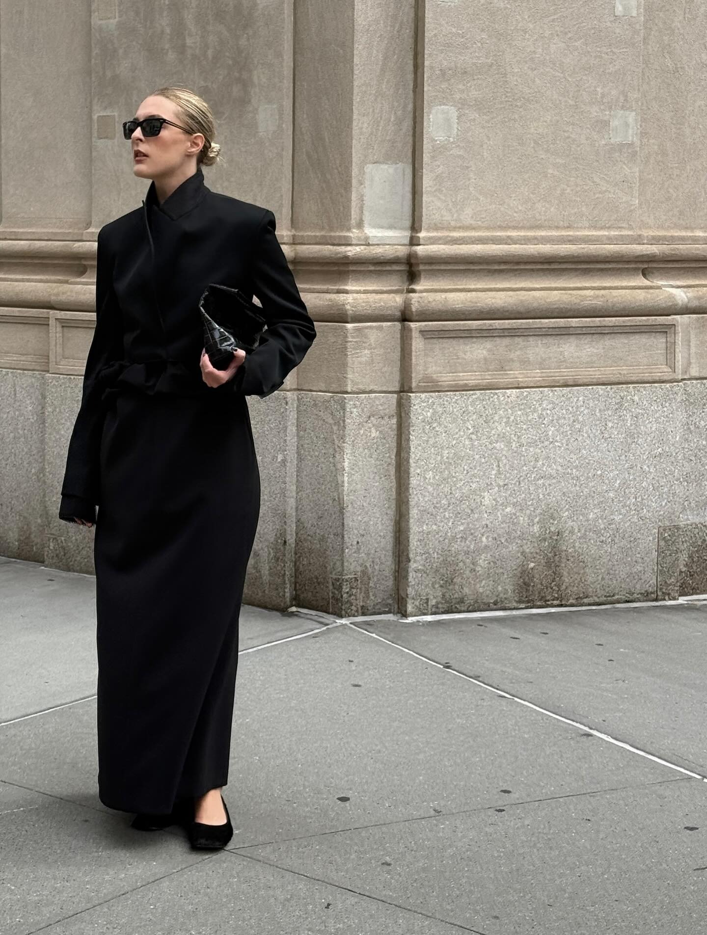 @christietyler wears a pair of calf-hair shoes by the Row with an floor length black overcoat.