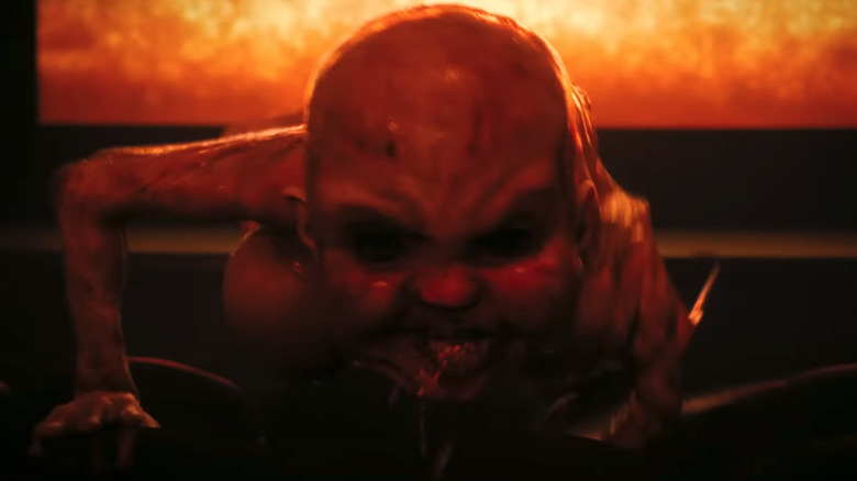 Demon baby crawls towards camera in a movie theater in It Welcome to Derry