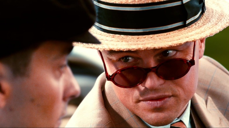 Leonardo DiCaprio's Jay Gatsby looks over his sunglasses at Tobey Maguire's Nick Carraway while driving in The Great Gatsby